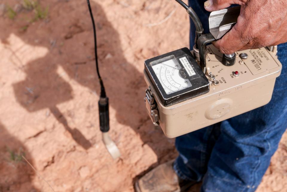 Radiation levels register over 2 millirems per hour on a Geiger counter at a uranium tailings pile located in Henry and Perry Tso's childhood backyard on the Navajo reservation in Tse Tah, Arizona. The EPA says that's over 100 times the expected background radiation level for the region. 