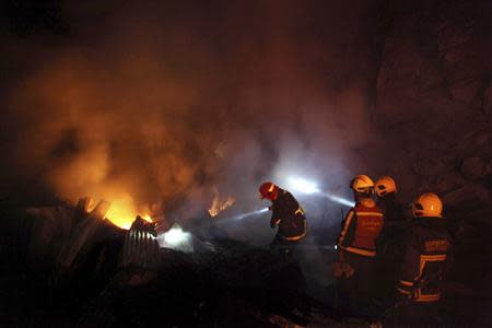 Firefighters work to put out a fire in Valparaiso city, northwest of Santiago