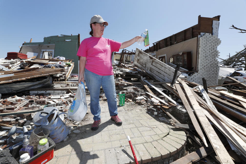 Julie Davis gestures as she speaks about her stepmother's house, now leveled from Sunday's tornado, Tuesday, April 14, 2020, in the Williamsburg community in rural Jefferson Davis County, Miss. The severe storm destroyed several neighborhoods and caused at least 12 fatalities statewide. (AP Photo/Rogelio V. Solis)