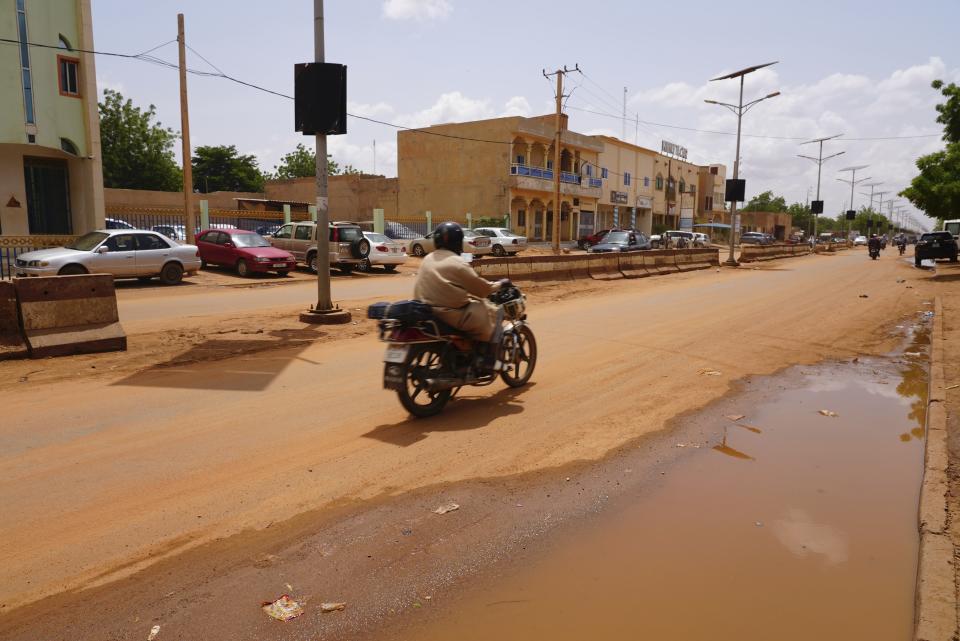 A lone motorcyclist rides in Niamey, Niger, Friday, July 28, 2023. The general who led a coup in Niger defended the takeover on state television and asked for support from the nation and international partners, as concerns grew that the political crisis could set back the country's fight against jihadists and increase Russia's influence in West Africa. (AP Photo/Sam Mednick)