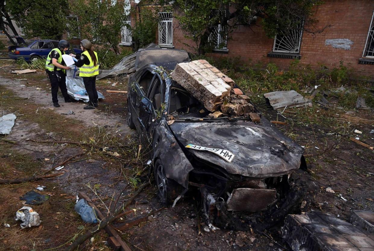 PHOTO: Police experts work next to a destroyed car near an industrial area of Kyiv, Ukraine, on Sept. 21, 2023, after Russian missile strikes overnight. (Sergei Supinsky/AFP via Getty Images)