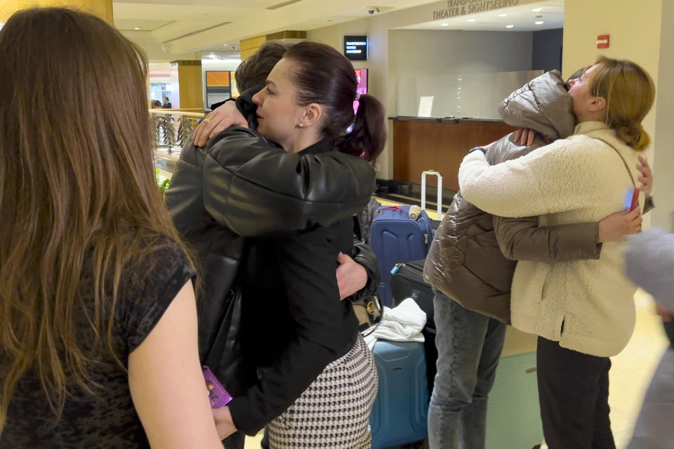 Halyna Protsyk, left center, Director of International Academic Relations for the Ukranian Catholic University, in Lviv, Ukraine, joins tearful goodbyes, as Ukrainian students depart, April 8, 2022, after spending nearly a week at the National Model United Nations Conference in New York. (AP Photo/Bobby Caina Calvan)
