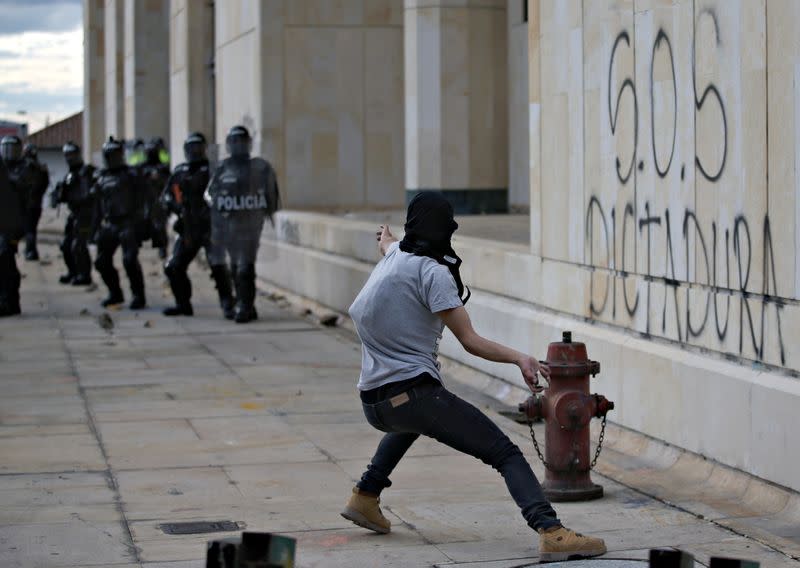 Un manifestante lanza un proyectil hacia la policía antidisturbios durante una protestaen un paro nacional, en Bogotá, Colombia, el 21 de septiembre de 2020.