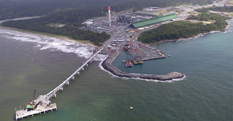 Mine refining facility on a coastline with a terminal jutting into the water.