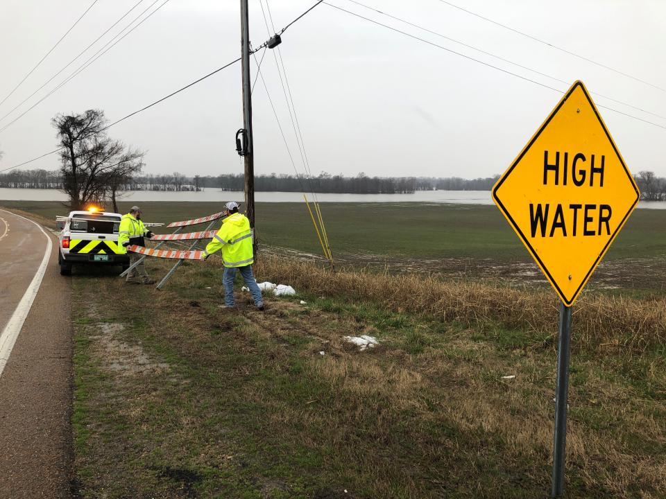 Transportation workers prepare to block rural Highway 88 in West Tennessee due to rising flood waters on Tuesday, Feb. 18, 2020, in Halls, Tenn. Forecasters expected more heavy rains in parts of the flood-ravaged South on Tuesday. (AP Photo/Adrian Sainz)