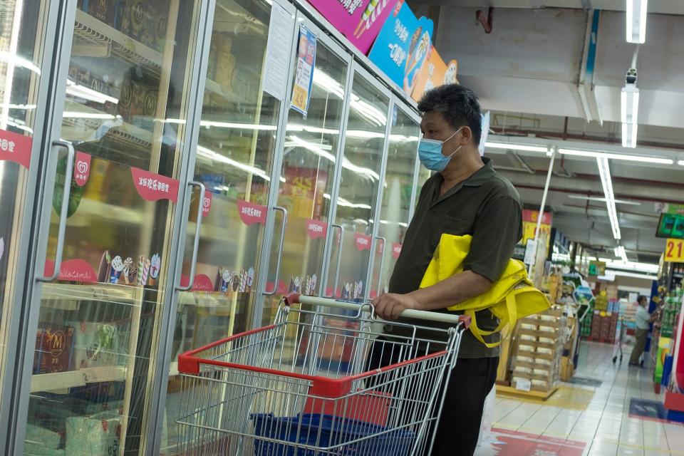 Image: A man looks at frozen food products in a supermarket in Beijing (Thomas Peter / Reuters)