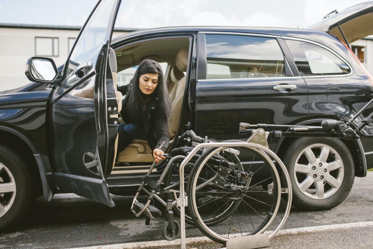 <span class="caption">People with disabilities may need larger cars or specially modified ones to be able to get themselves around.</span> <span class="attribution"><a class="link " href="https://www.gettyimages.com/detail/photo/young-disabled-woman-holding-wheelchair-by-car-on-royalty-free-image/1207327237" rel="nofollow noopener" target="_blank" data-ylk="slk:Maskot/DigitalVision via Getty Images;elm:context_link;itc:0;sec:content-canvas">Maskot/DigitalVision via Getty Images</a></span>