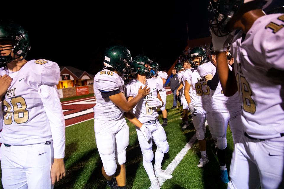 Zeeland West celebrate their win over Muskegon to remain undefeated and in control of the OK Green Conference Friday, Sept. 23, 2022, at Muskegon's Hackley Stadium. 