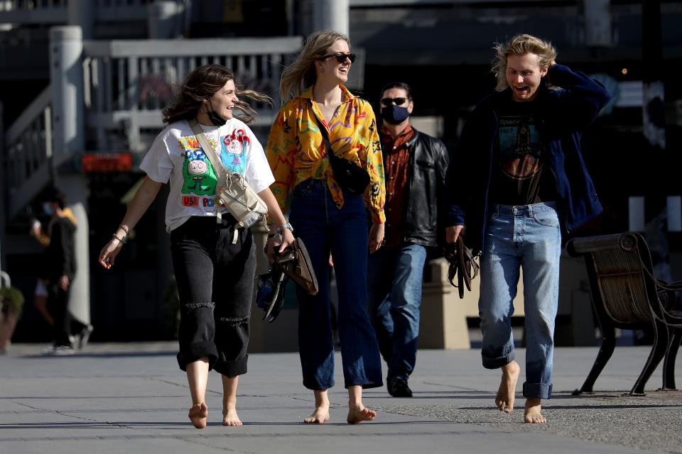 REDONDO BEACH, CA - APRIL 27: People walk along the boardwalk on Tuesday, April 27, 2021 in Redondo Beach, CA. U.S. health officials say fully vaccinated Americans dont need to wear masks outdoors anymore unless they are in a big crowd of strangers (Associated Press). (Gary Coronado / Los Angeles Times via Getty Images)