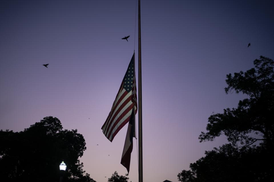 The American and Texas flags are flown at half mast at dusk on Thursday, May 26, 2022, days after a deadly school shooting, in Uvalde, Texas. In a town as small as Uvalde, even those who didn't lose their own child lost someone. Some say now that closeness is both their blessing and their curse: they can lean on each other to grieve. But every single one of them is grieving. (AP Photo/Wong Maye-E)