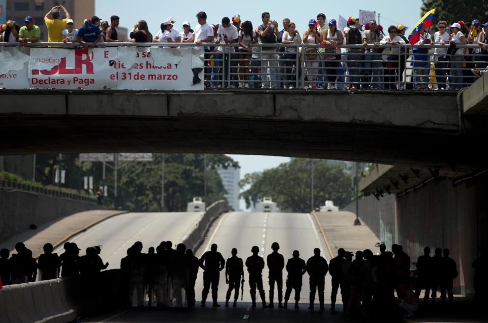 Bolivarian National Guardmen block a road to prevent demonstrators from reaching the Food Ministry, in Caracas, Venezuela, Saturday, March 8, 2014. Venezuelans returned to the streets for the "empty pots march" to highlight growing frustration with shortages of some everyday items. In Caracas, the march was scheduled to end at the country's Food Ministry, but the evening before Caracas' mayor announced that he had not authorized the march. (AP Photo/Fernando Llano)