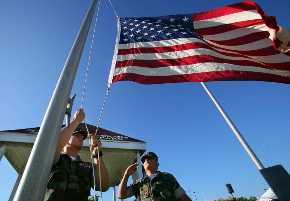 DeSoto Young Marines Staff Sgt. William Robinson and PFC Steven Ruch raise one of the flags surrounding the Veterans’ Memorial before the annual service in 2011 on the riverfront of the Manatee River.