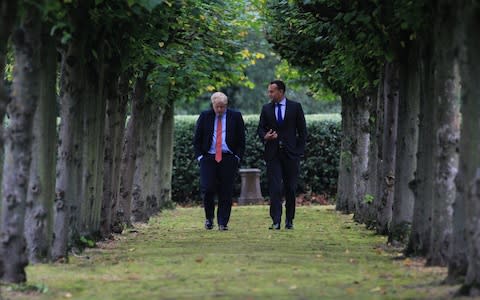 British Prime Minister Boris Johnson (L) walks with Ireland's Taoiseach Leo Varadkar (R) in the grounds of Thornton Manor Hotel near Birkenhead on October 10, 2019 in Liverpool