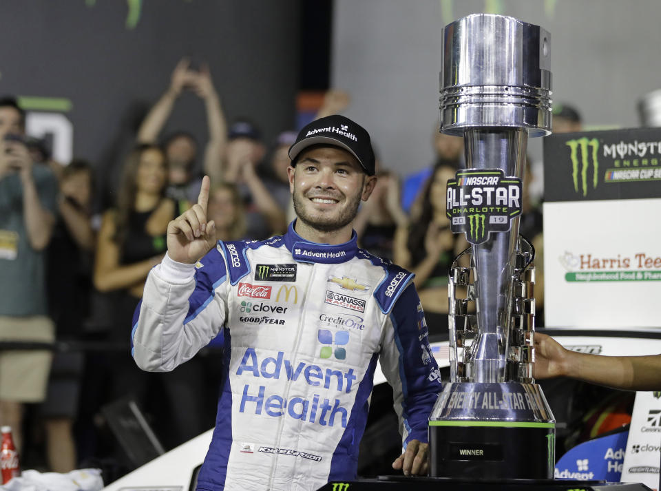 FILE - In this May 18, 2019, file photo, Kyle Larson poses with the trophy after winning the NASCAR All-Star Race at Charlotte Motor Speedway in Concord, N.C. Larson will be back in NASCAR next season driving the flagship No. 5 Chevrolet for Hendrick Motorsports after signing a multi-year contract Wednesday morning, Oct. 28, 2020, with Hendrick that ended his seven-month banishment from NASCAR for using a racial slur while playing an online racing game. (AP Photo/Chuck Burton, File)