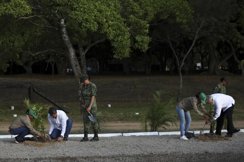 Honduras' President Juan Orlando Hernandez, second from left, and Mexico's President Andrés Manuel López Obrador, right, plant trees as part of the Mexican program "Sembrando Vida," on the military base in Minatitlan, Mexico, Saturday, July 27, 2019. Lopez Obrador said Saturday that Honduras will adopt a Mexican program to put people to work planting trees and also will copy a Mexican program which pays a small monthly stipend to young people while they are studying, in an effort to help stem the tide of Central American migrants seeking asylum in the U.S. (AP Photo/Felix Marquez)