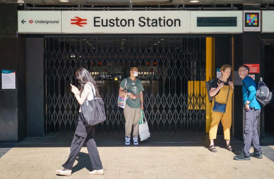 People stand outside the closed entrance to Euston station in London (Dominic Lipinski/PA) (PA Wire)