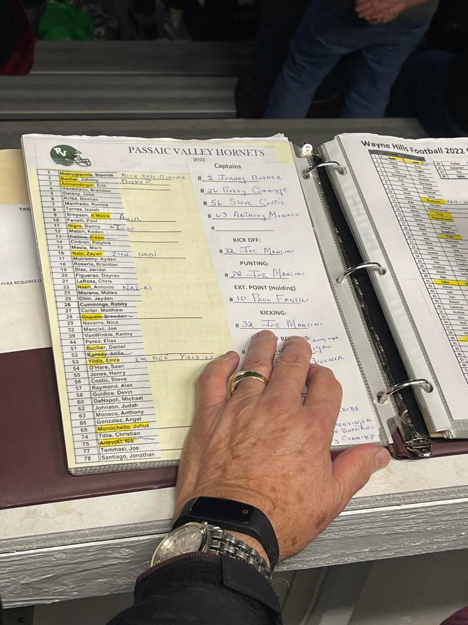 Wayne Hills High School football announcer Ernie Mezey reviewing player information and stats at the Oct. 14, 2022 game against the Passaic Valley Hornets.