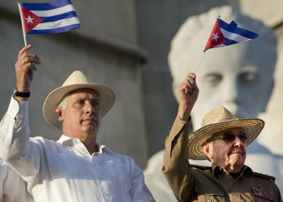 FILE - In this May 1, 2019 file photo, Cuba's President Miguel Diaz-Canel, left, and former Cuban President Raul Castro wave Cuban flags as they watch the annual May Day parade file past at Revolution Square in Havana, Cuba. On Monday, April 19, 2021, Cuba's Communist Party congress chose Díaz-Canel to be its leader, adding that post to the title of president he assumed in 2018, replacing his mentor Raul Castro and sealing a political dynasty that had held power since the 1959 revolution. (AP Photo/Ramon Espinosa, File)