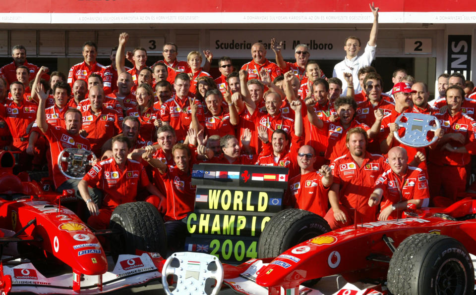 Schumacher (R) and Ferrari team members celebrate in the pits of the Hungaroring racetrack after the Hungarian Grand Prix in Budapest, Hungary. (AFP)