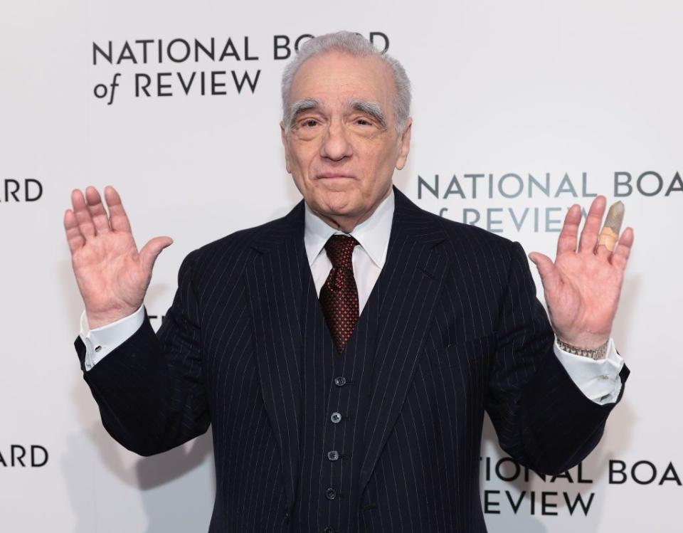 martin scorsese holding up his hands and looking forward as he stands for a photograph