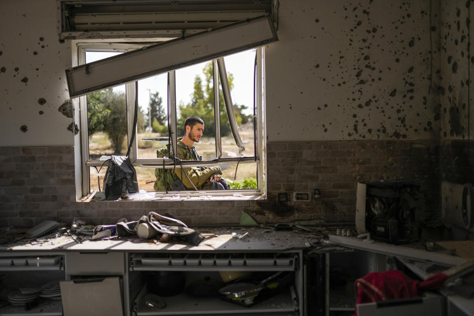An Isreal soldier patrols next to a house damaged by Hamas militants at Kibbutz Kissufim in southern Israel, Saturday, Oct. 21, 2023. The Kibbutz was stormed by Hamas militants from the nearby Gaza Strip on Oct. 7, when they killed and captured many Israelis. (AP Photo/Francisco Seco)