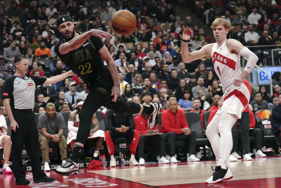 New Orleans Pelicans forward Larry Nance Jr. (22) passes the ball as Toronto Raptors guard Gradey Dick (1) looks on during the first half of an NBA basketball game in Toronto on Tuesday, March 5, 2024.(Nathan Denette/The Canadian Press via AP)