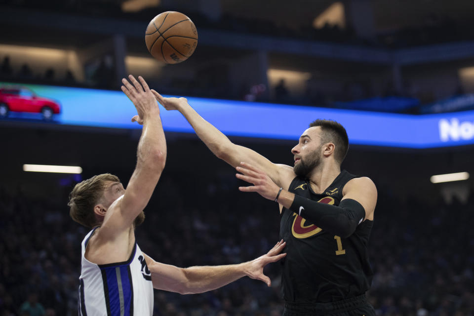 Cleveland Cavaliers guard Max Strus (1) flips a pass over Sacramento Kings forward Domantas Sabonis, left, in the first quarter of an NBA basketball game in Sacramento, Calif., Monday, Nov. 13, 2023. (AP Photo/José Luis Villegas)