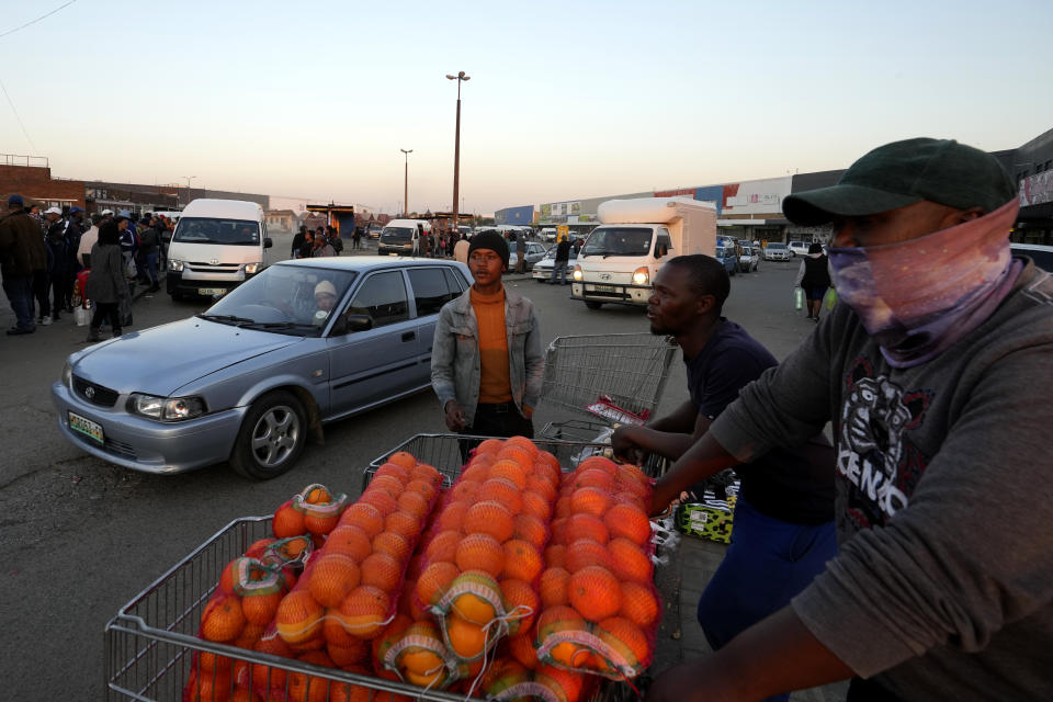 A street vendor selling oranges at a taxi rank in Welkom, South Africa, Friday, June 23, 2023. At least 31 people were believed to have died in a gas explosion in a disused mine shaft in the city of Welkom that happened last month but was only now coming to light, authorities said Friday. (AP Photo/Themba Hadebe)