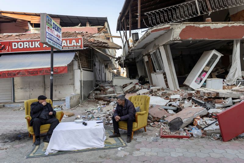 Dos hombres frente a propiedades destruidas tras el terremoto en Antioquía