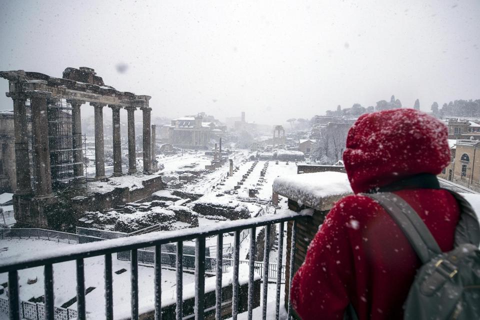 ROM03. ROMA (ITALIA), 26/02/2018.- Una turista contempla el Fori Imperiali completamente nevado, en Roma, Italia, hoy, 26 de febrero de 2018. La ola de frío siberiano, que han llamado Burian, llegó ayer a Italia provocando copiosas nevadas en el norte y un frío intenso que ha llegado hasta los 20 grados bajo cero en algunas localidades y hoy alcanzó el centro del país y Roma, donde los colegios permanecen cerrados. EFE/ Angelo Carconi