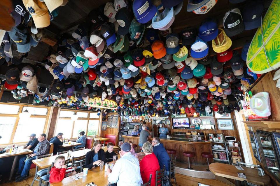 Hundreds of baseball caps decorate the ceiling of Sea Shanty in Cayucos, celebrating its 40th anniversary under owners Bill Shea and Carol Kramer.