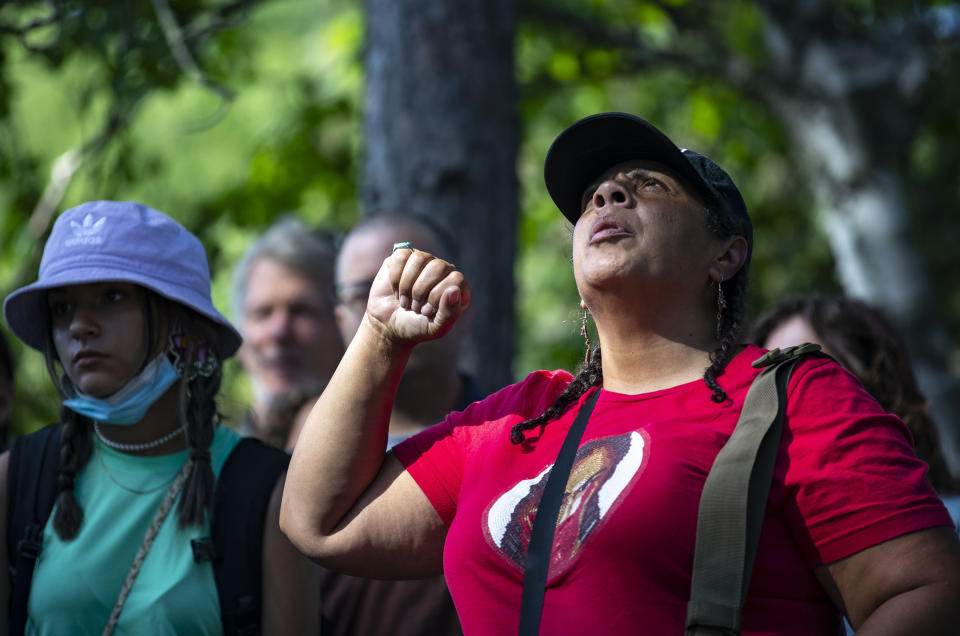 An Indigenous woman raises her fist during an interfaith prayer circle at LaSalle Lake State Recreation Area, on Monday, June 7, 2021, in Clearwater County, Minn., to protest the construction of Enbridge Line 3. More than 2,000 Indigenous leaders and "water protectors" gathered in Clearwater County from around the country. The day started with a prayer circle and moved on to a march to the Mississippi headwaters where the oil pipeline is proposed to be built. (Alex Kormann/Star Tribune via AP)