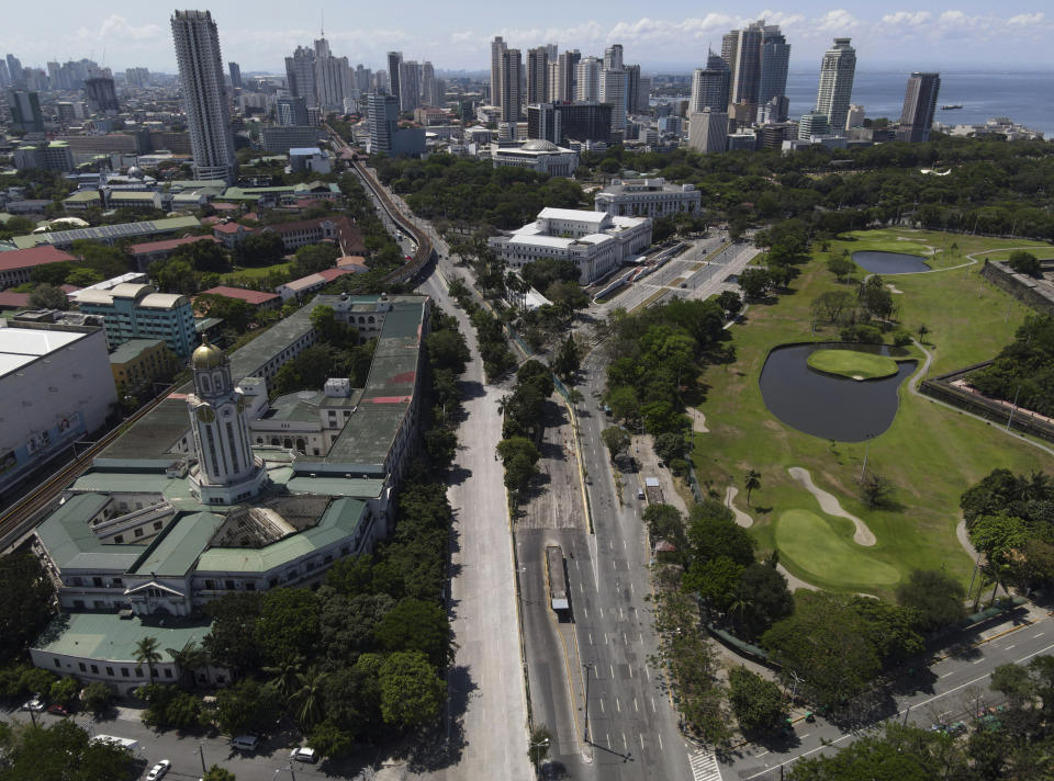 The Manila City Hall stands beside an almost empty road as the government implements a strict lockdown to prevent the spread of the coronavirus on Good Friday, April 2, 2021 in Manila, Philippines. Filipinos marked Jesus Christ's crucifixion Friday in one of the most solemn holidays in Asia's largest Catholic nation which combined with a weeklong coronavirus lockdown to empty Manila's streets of crowds and heavy traffic jams. Major highways and roads were eerily quiet on Good Friday and churches were deserted too after religious gatherings were prohibited in metropolitan Manila and four outlying provinces. (AP Photo/Aaron Favila)