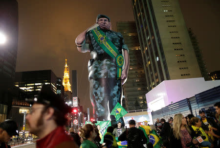 Supporters of Jair Bolsonaro, far-right lawmaker and presidential candidate of the Social Liberal Party (PSL), stand near a giant doll depicting Bolsonaro's candidate for vice president Hamilton Mourao, in Sao Paulo, Brazil October 7, 2018. REUTERS/Ueslei Marcelino