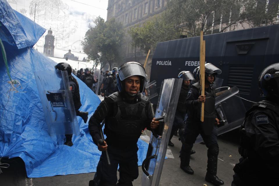Riot policemen charge towards protesters in downtown Mexico City September 13, 2013. Police used tear gas and water cannons to disperse demonstrators in the main square of Mexico City on Friday, arresting 31 people, as the government took control of the historic center after weeks of protests by teachers. (REUTERS/Tomas Bravo)