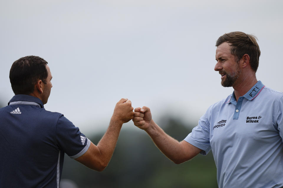 Webb Simpson, right, bumps fists with Sergio Garcia, of Spain, on the 18th hole during the second round of the Masters golf tournament on Friday, April 9, 2021, in Augusta, Ga. (AP Photo/David J. Phillip)