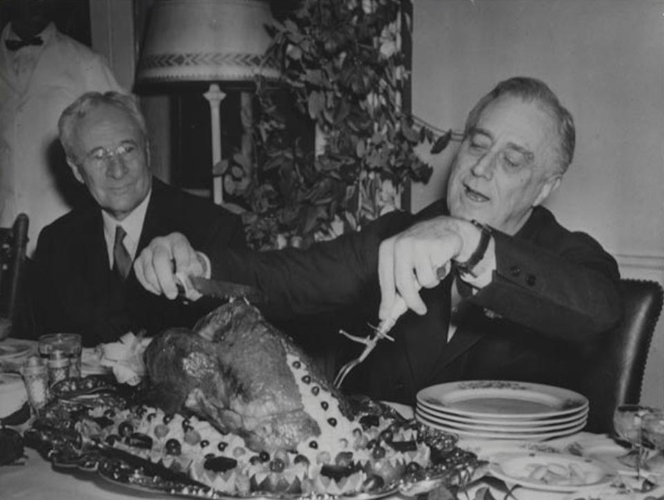 El presidente estadounidense Franklin Roosevelt corta el pavo durante una cena de Acción de Gracias en la década de 1930. (National Archives)