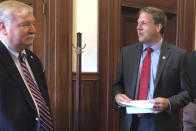 FILE - New Hampshire Gov. Chris Sununu, right, talks with former Democratic N.H. House Speaker Steve Shurtleff at the State House on Sept. 25, 2019, in Concord, N.H. Sununu, called the primary calendar shift “a horrible miscalculation” for President Joe Biden that exposes him to a legitimate primary challenge. “He’s made it harder to win in November '24 — if he’s the nominee,” Sununu said in an interview. “But because of what he did here, he very well may not be the nominee.” (AP Photo/Holly Ramer, File)
