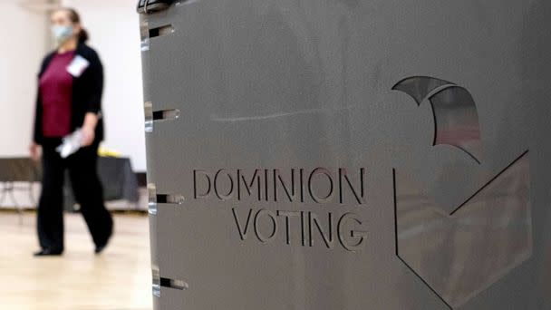 PHOTO: A worker passes a Dominion Voting ballot scanner while setting up a polling location at an elementary school in Gwinnett County, Ga., Jan. 4, 2021. (Ben Gray/AP, FILE)