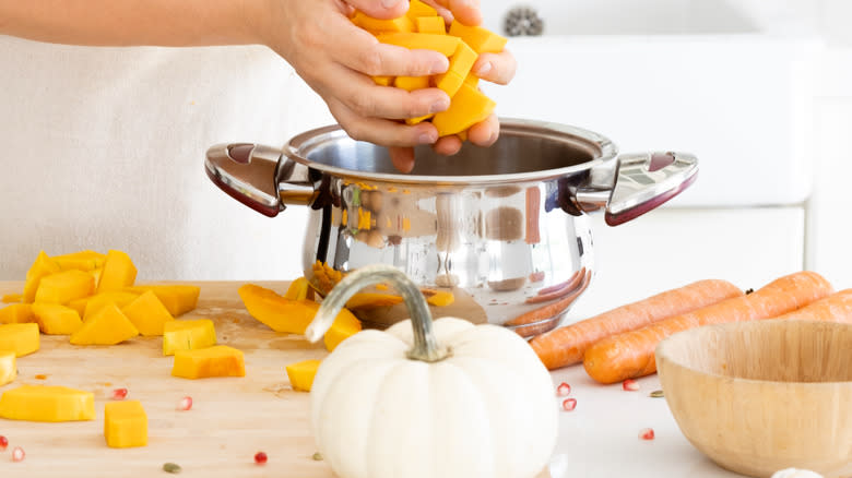 Person making pumpkin soup