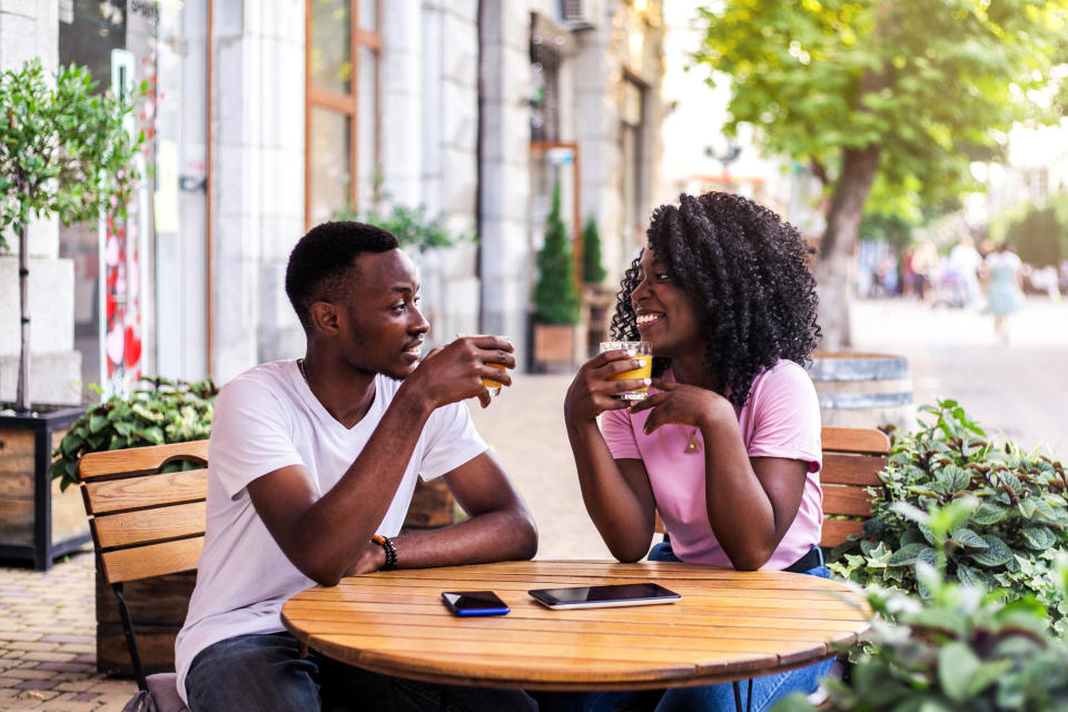 Portrait of couple talking to each other at summer street cafe.