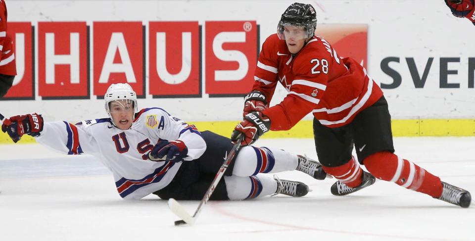 Canada's Mantha and United States' Grzelcyk battle for the puck during the second period of their IIHF World Junior Championship ice hockey game in Malmo