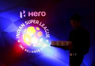 FILE PHOTO: A waiter walks past a logo of Indian Super League before a news conference during the domestic player auction and draft in Mumbai