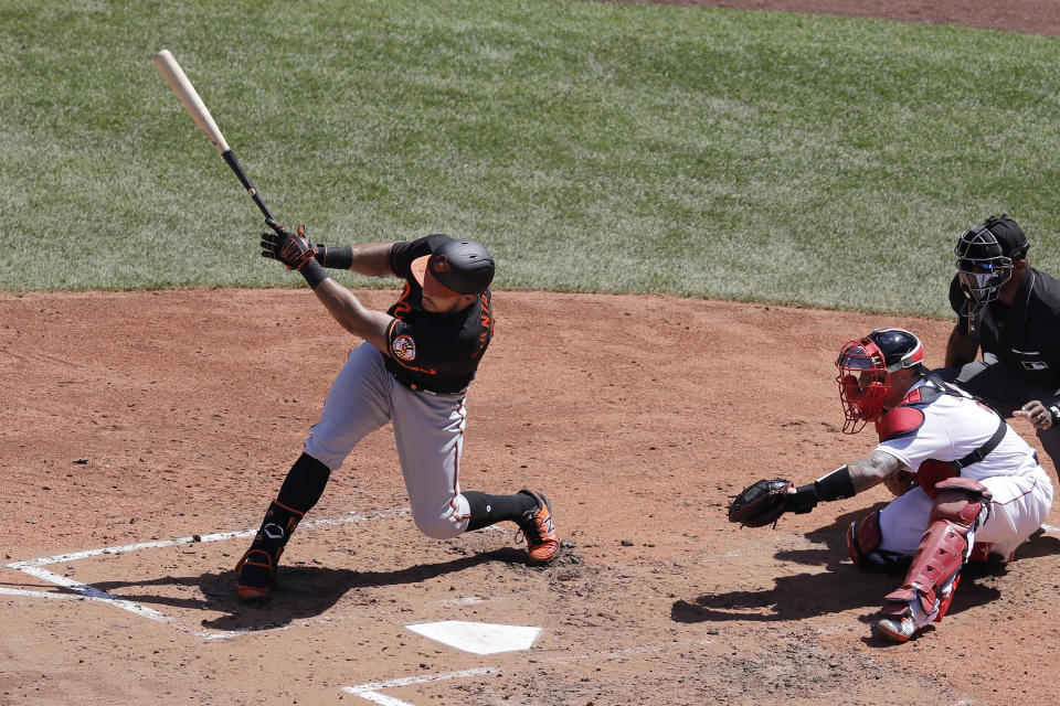 Baltimore Orioles' Anthony Santander, left, hits a two-run home run as Boston Red Sox's Christian Vazquez, second from right, looks on during the fourth inning of a baseball game Sunday, July 26, 2020, in Boston. (AP Photo/Steven Senne)
