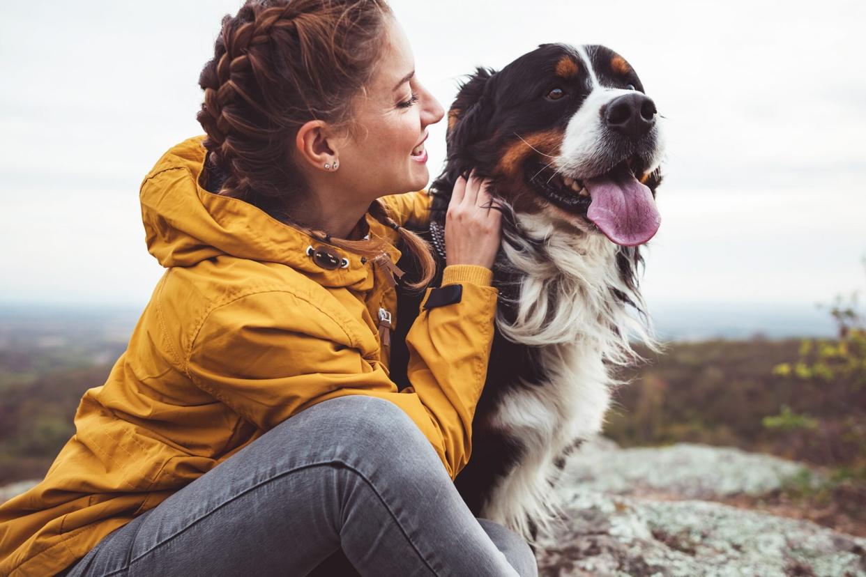 Young woman in yellow coat with dog