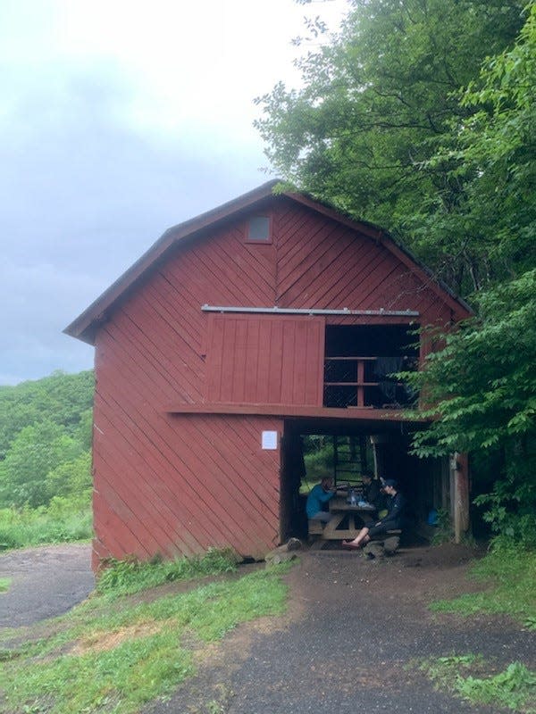 In this photo captured June 7, 2019, hikers sit and rest at Overmountain Shelter along the Appalachian Trail in Newland, N.C. Less than three months later, the shelter was closed after engineers determined that the building had become structurally unsound.