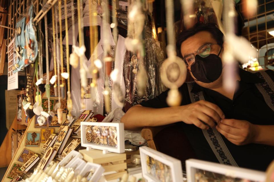 A man wearing a mask stands in a shop