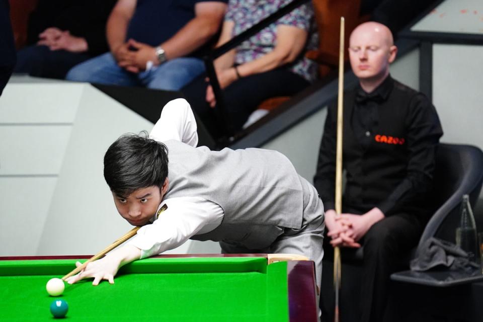 Anthony McGill watches on as Si Jiahui takes to the table (PA)