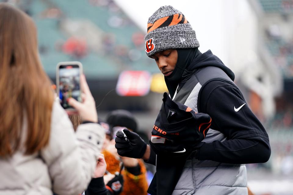 Cincinnati Bengals wide receiver Tee Higgins (5) signs autographs for fans prior to the Week 18 NFL football game with the Cleveland Browns Jan. 7, 2024, at Paycor Stadium.