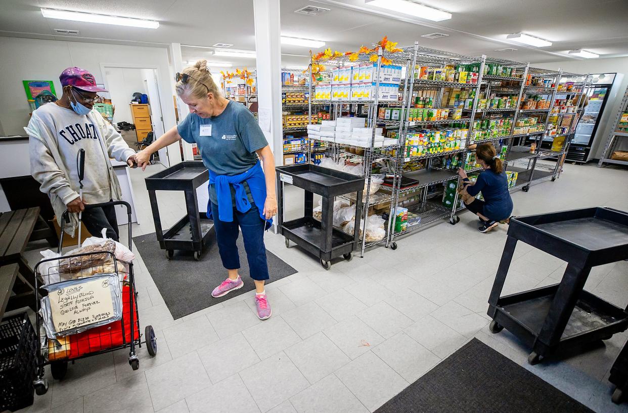 Deb Nelson, a volunteer at the Community Cooperative in Fort Myers, helps Anthony Armstrong shop in the Cooperative's community market in Fort Myers recently.